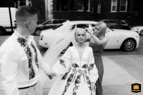 At the Sts. Volodymyr and Olha Ukrainian Catholic Church, a WPJA wedding photographer captures a heartfelt, candid moment. The black-and-white image shows the bride, in her intricately embroidered gown, having her veil adjusted as the groom lovingly holds